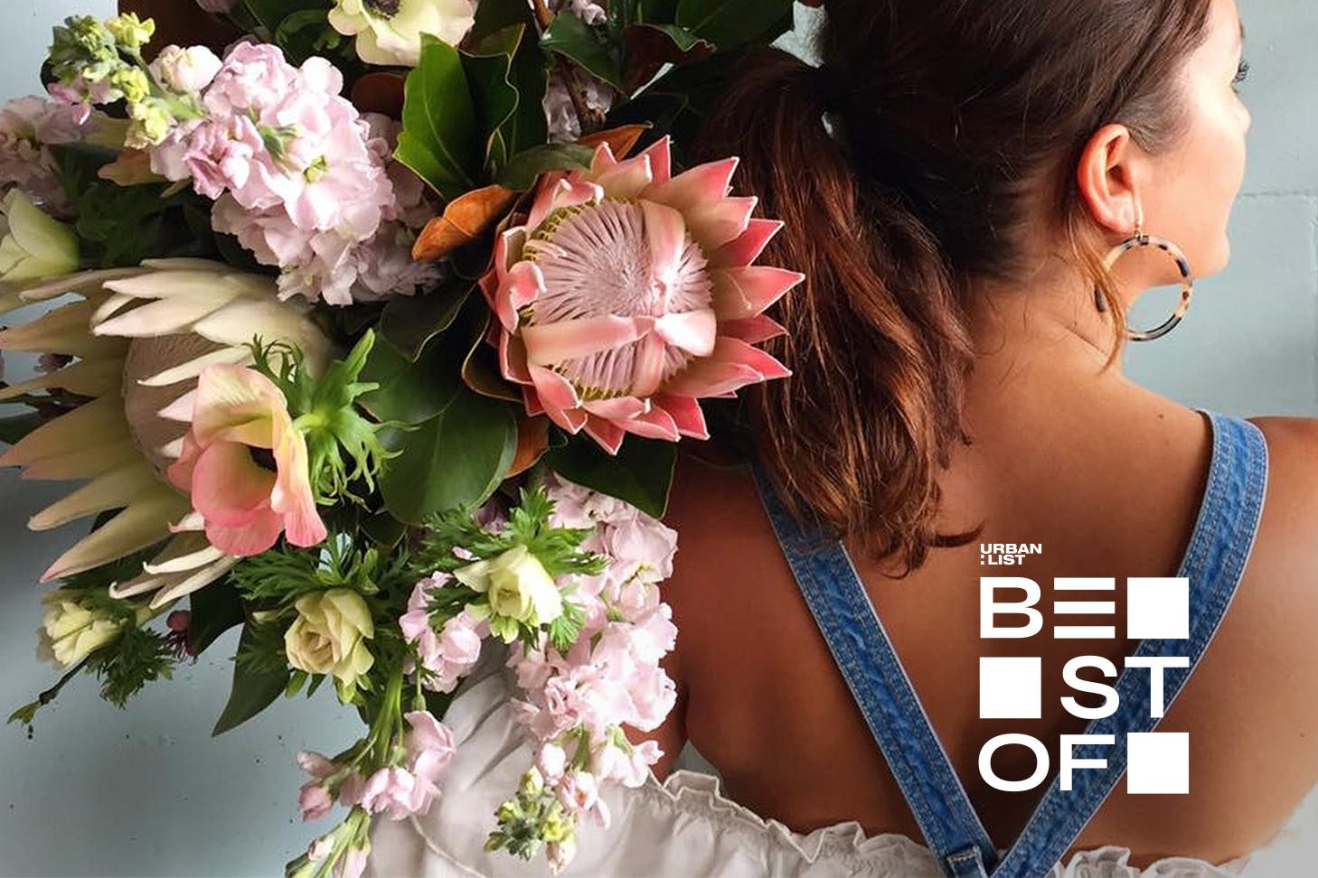 A girl holds a beautiful bouquet over her shoulder at The Botanist. One of Auckland's best flower delivery businesses.